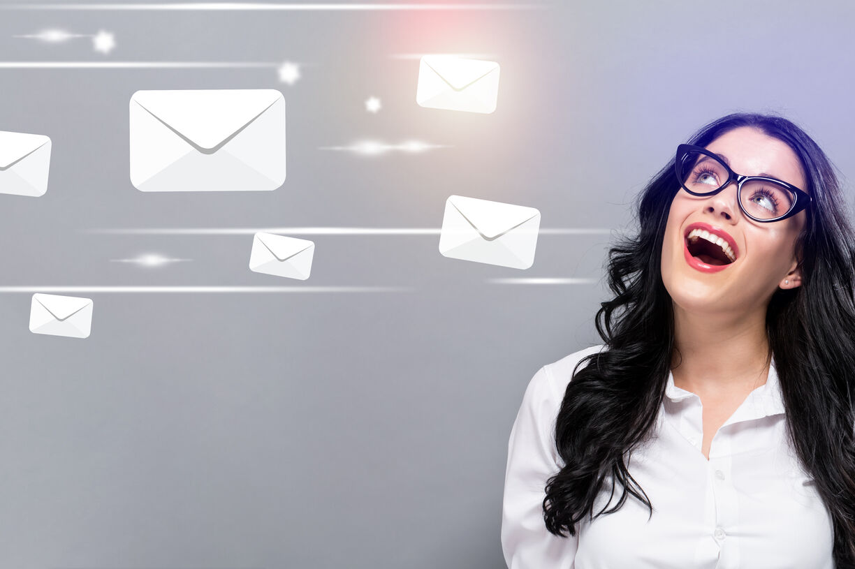 Email Marketing Trends 2023 Happy lady with black glasses smiling up at email envelopes